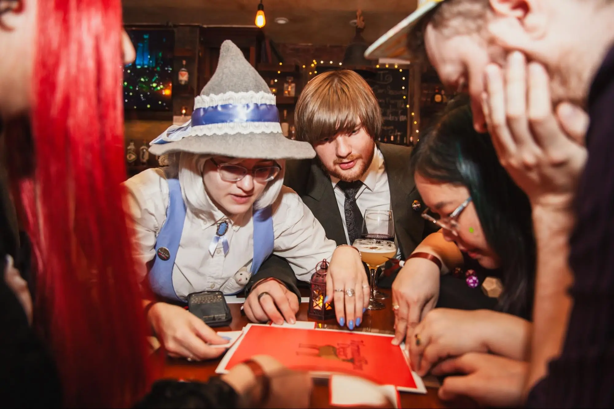 Players analyzing table top puzzle at Pocket Bard Tavern Launch Event 2024