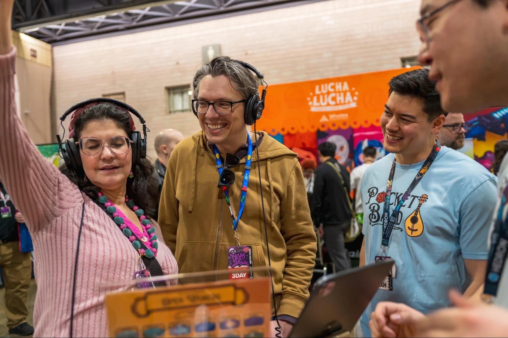 People trying Pocket Bard with headphones at a convention booth