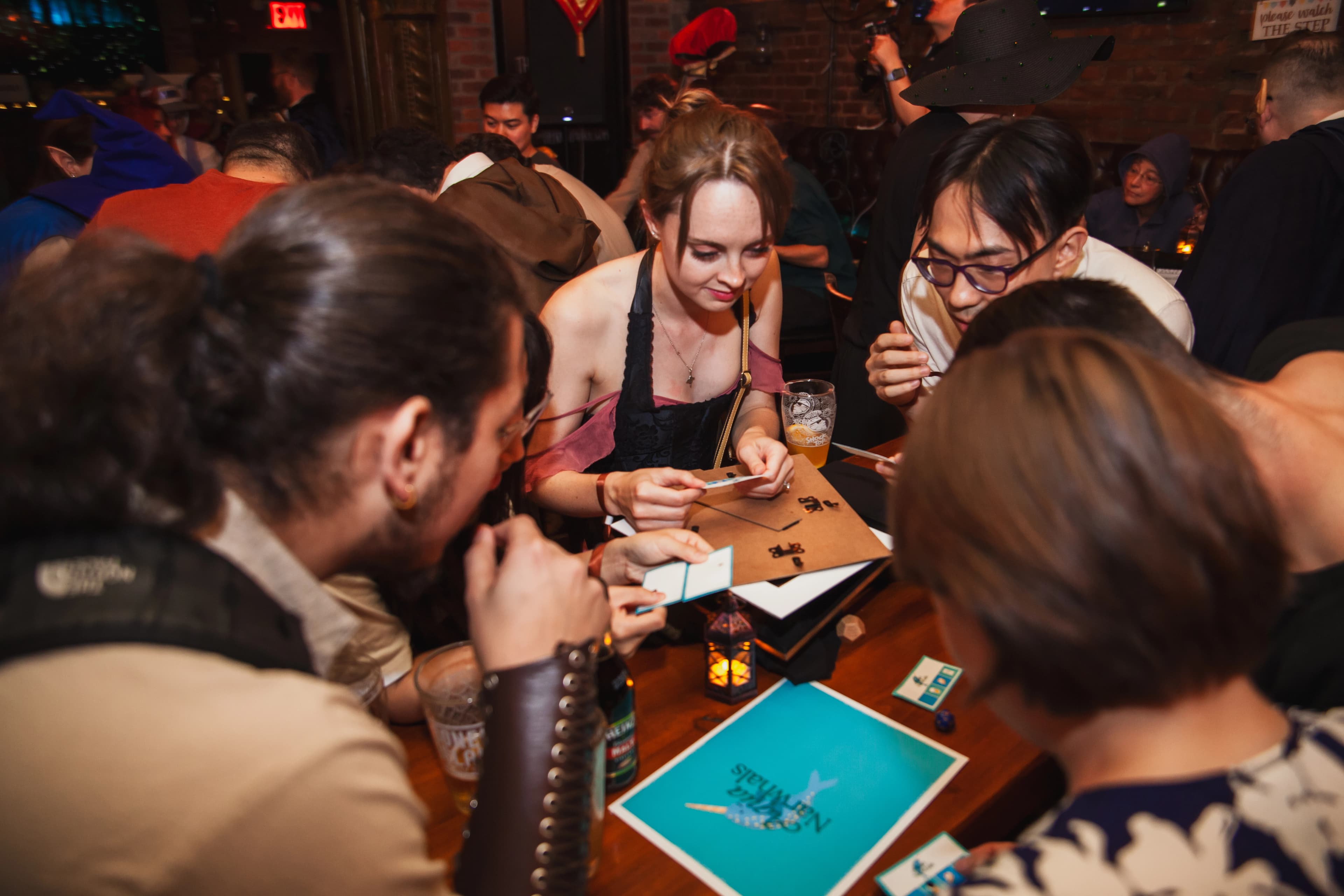 Players gathered around a tavern table, examining clue cards together at the Pocket Bard tavern event